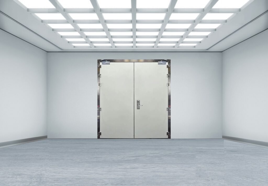 Bright cleanroom interior with a grid-lit ceiling and a sealed double metal door